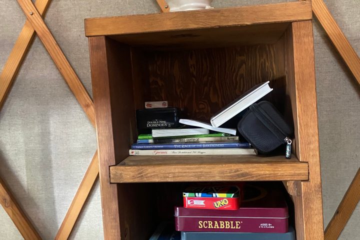 a wooden box sitting on top of a book shelf