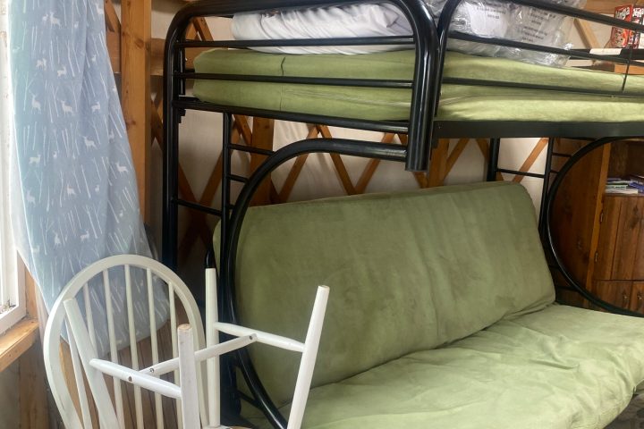 a bedroom with a bed and a chair in a room