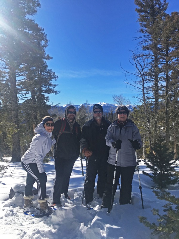 a group of people standing on top of a snow covered slope