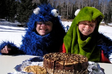a couple of people that are standing in front of a cake