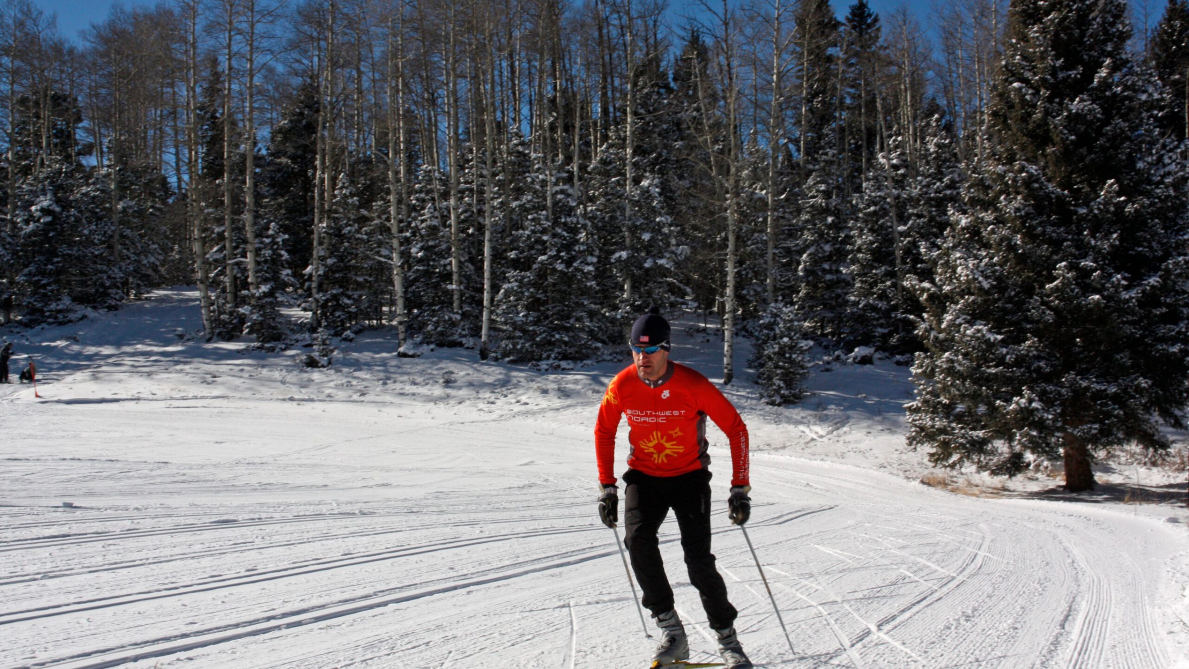 a man is cross country skiing on a snow covered slope