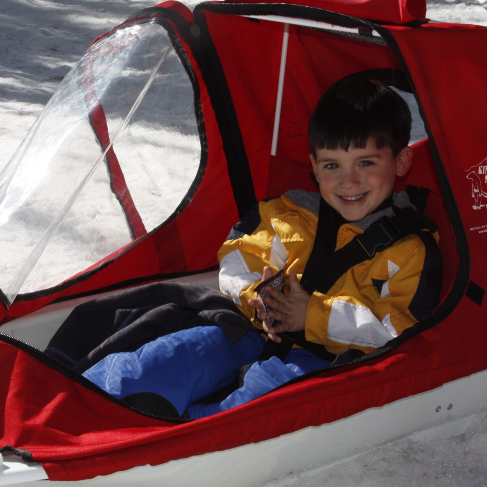 a little boy that is sitting in the snow