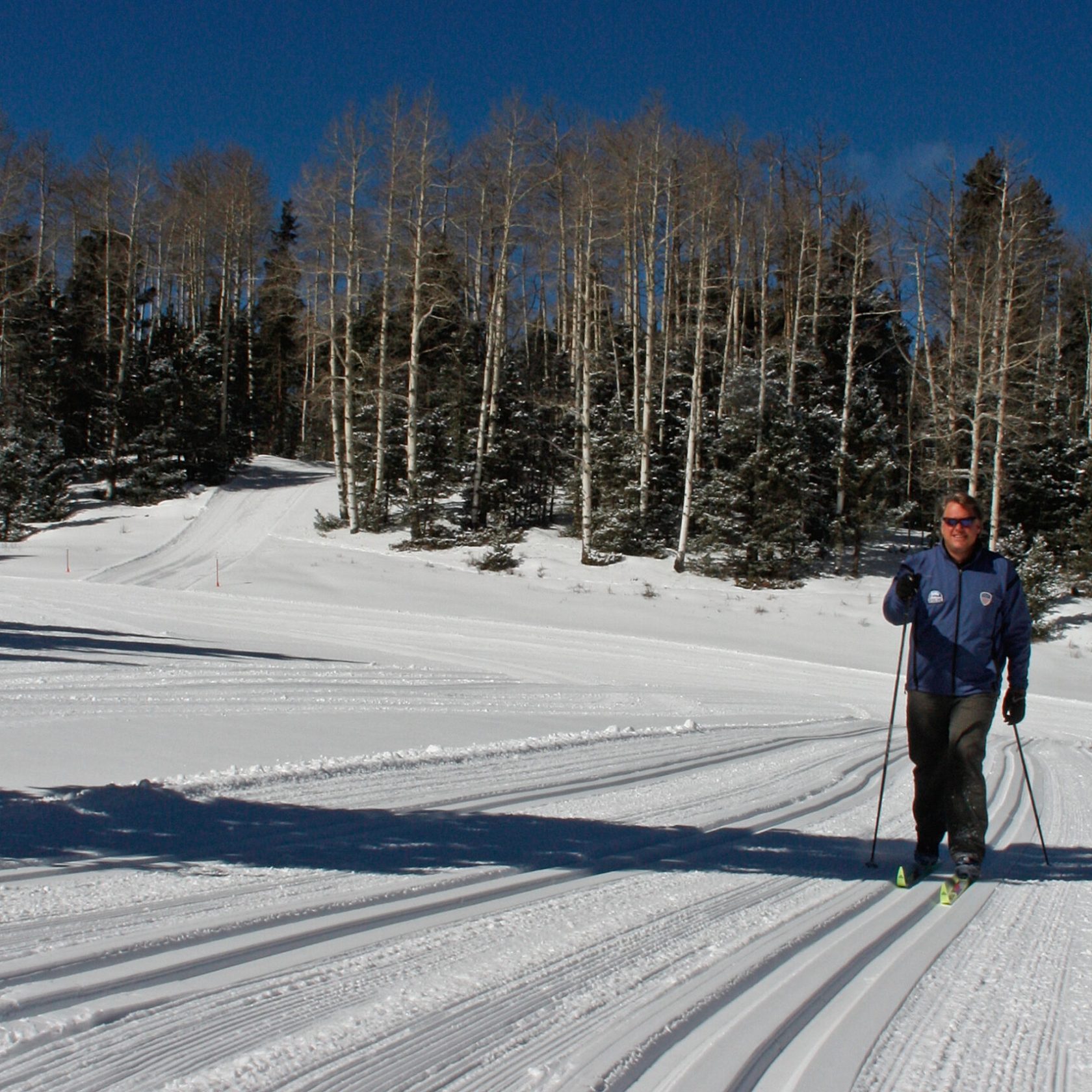 a man riding skis down a snow covered slope