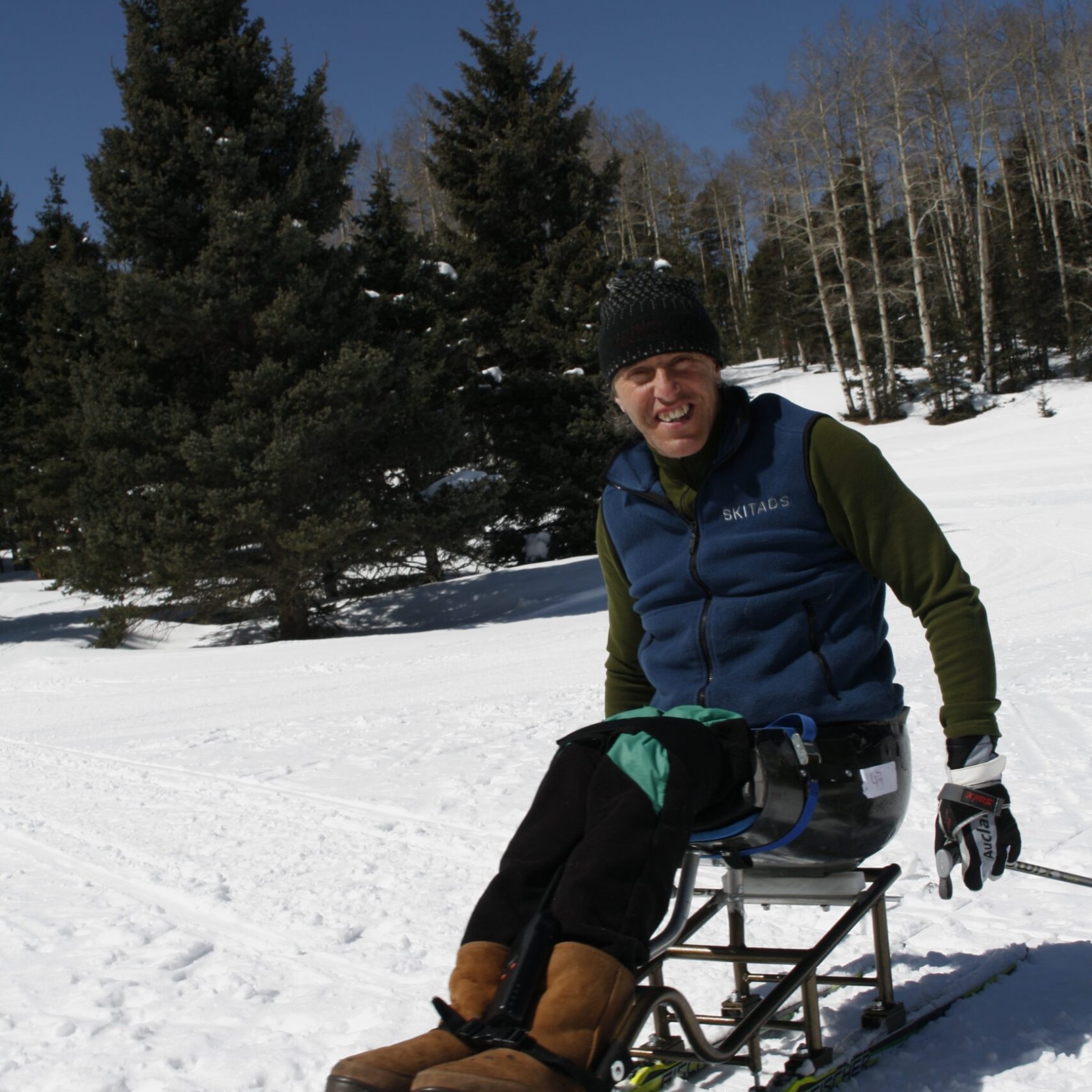 a person sitting on top of a snow covered slope