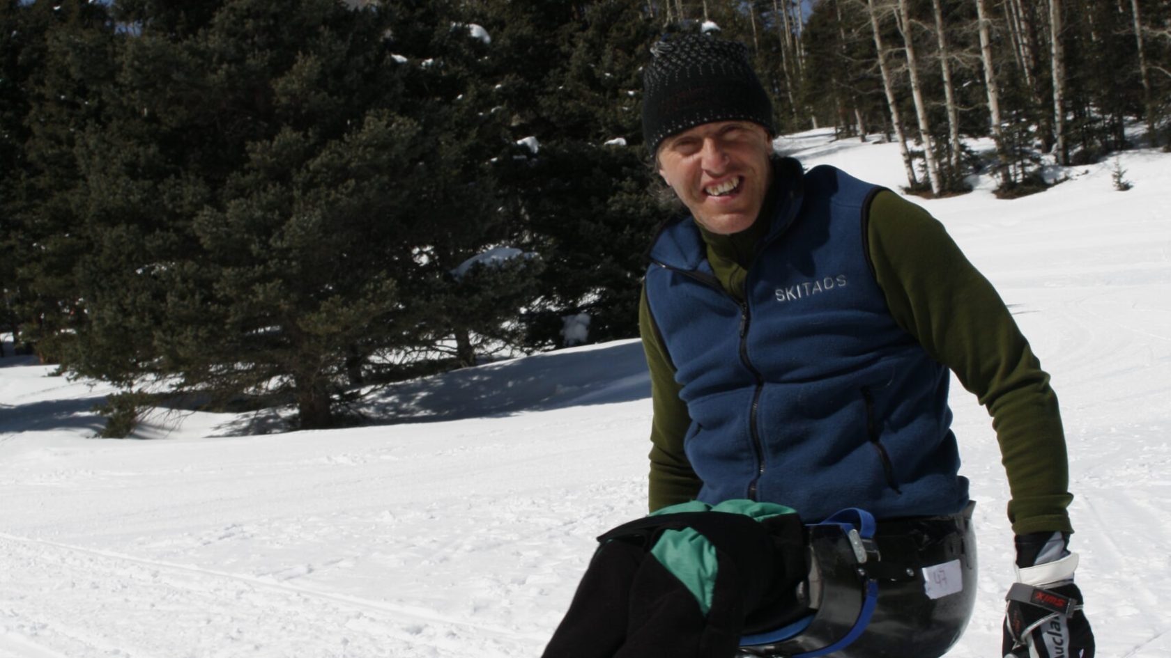 a person sitting on top of a snow covered slope