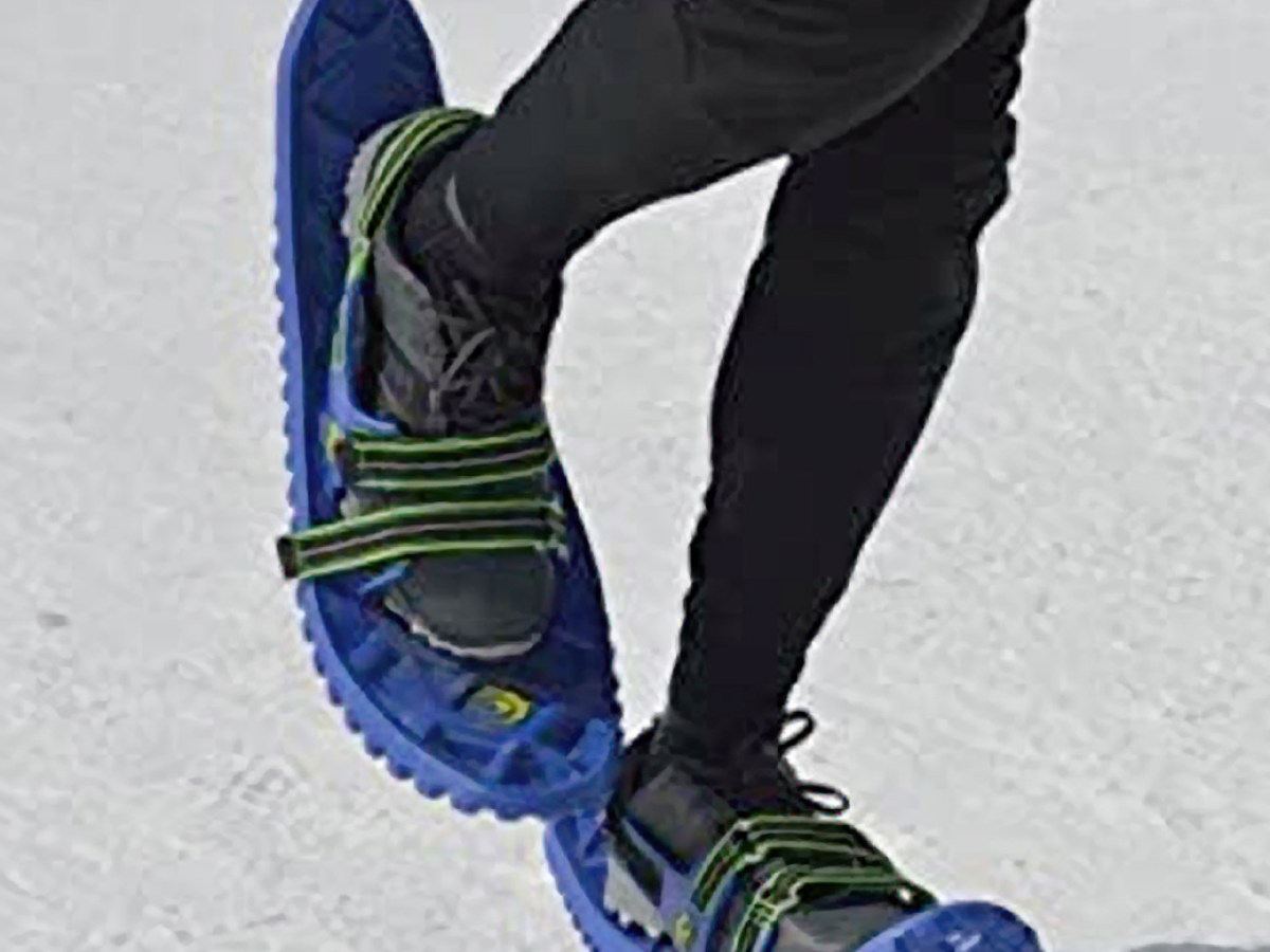 a person riding a snowboard down a snow covered slope