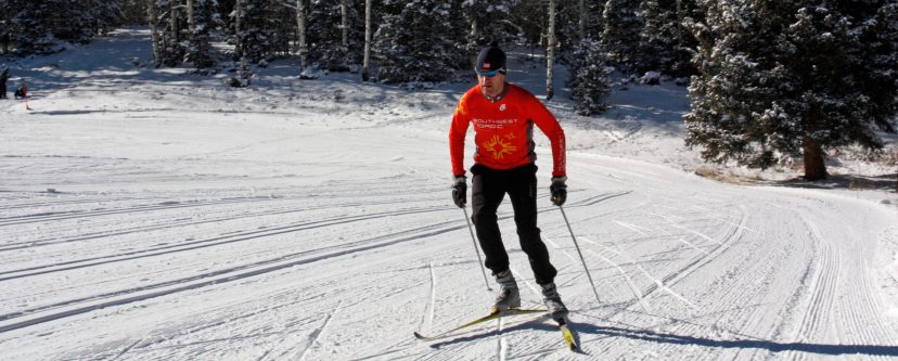 a man is cross country skiing on a snow covered slope